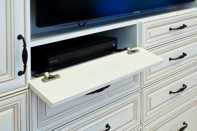 Keep visual clutter to a minimum by hiding electronics behind drop-front cabinetry.
